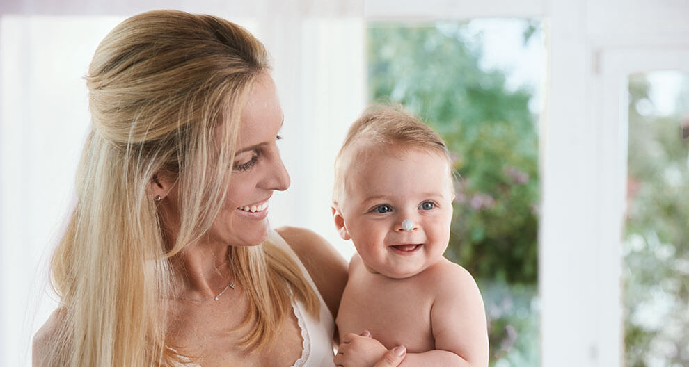 A woman holds a baby.