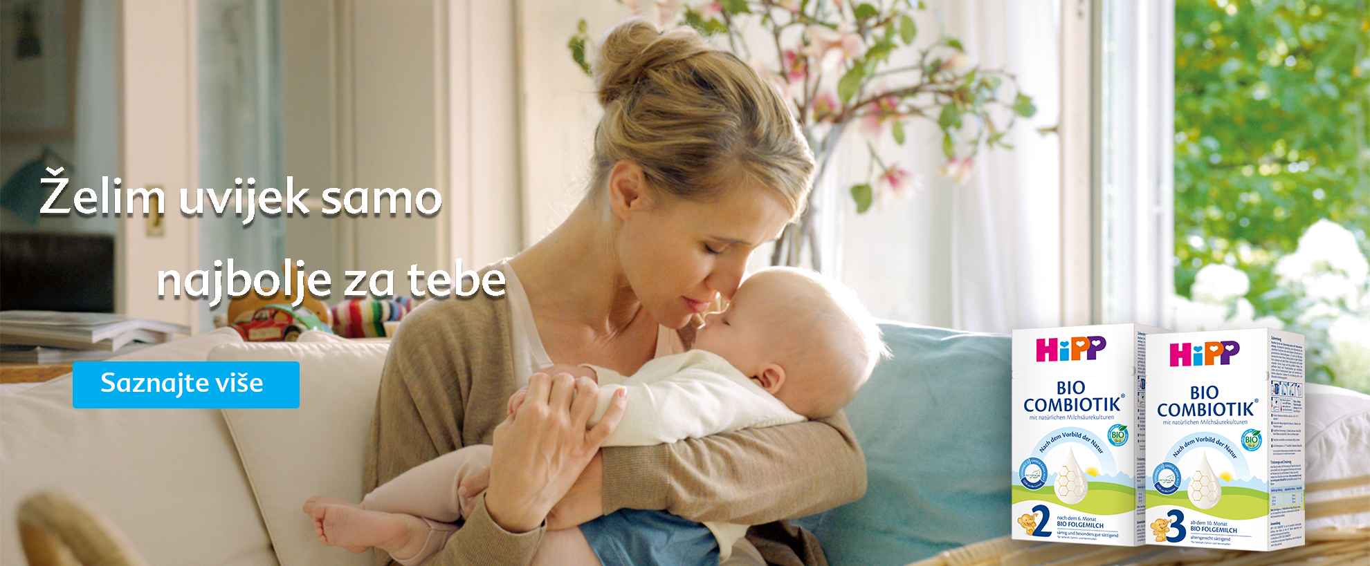 Majka s ljubavlju drži svoju bebu, a s desne strane je reklama za proizvod "HiPP BIO COMBIOTIK".