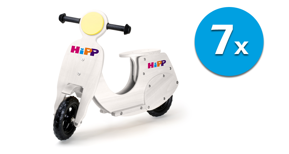 Bijeli drveni romobil s natpisom „HiPP“, popraćen plavim krugom s brojem „7“ i riječju „x“ unutra.