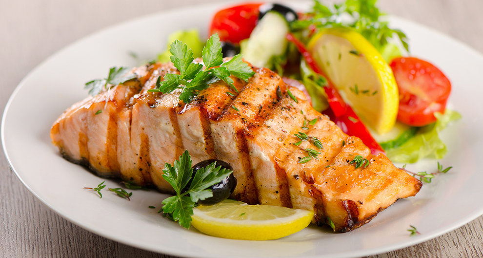 Tanjur pečenog lososa s prilogom od salate.