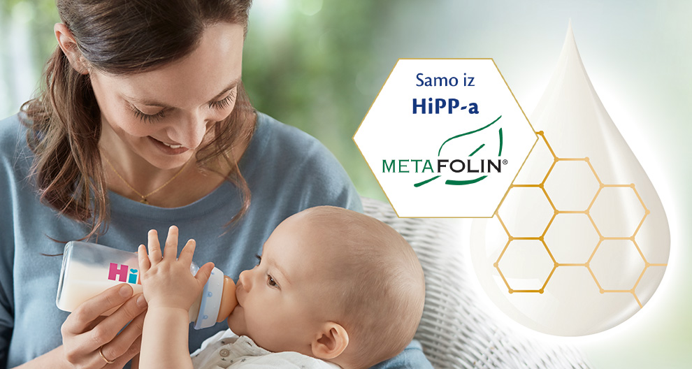 Žena hrani bebu bočicom koja sadrži bijelu tekućinu, dok grafika prikazuje kemijsku strukturu HiPP-a i robne marke Metafolin.