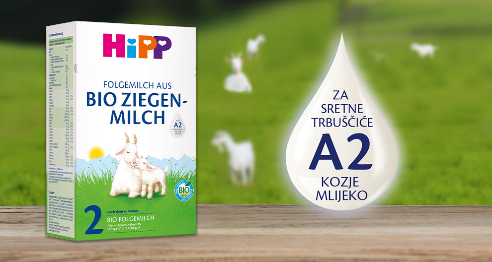 Kutija Hipp kozjeg mlijeka, faza 2, s pozadinom zelenog pašnjaka i koza na ispaši.